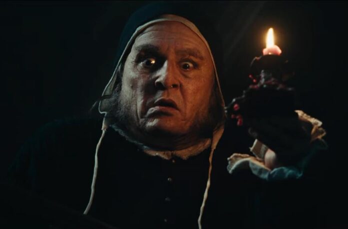 Johnny Depp as Ebenezer Scrooge in a dark, candlelit scene from Ti West’s upcoming adaptation of A Christmas Carol.