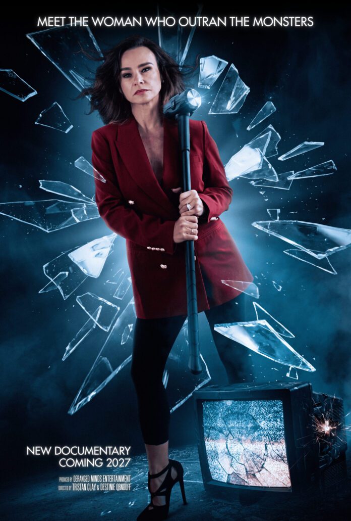 Danielle Harris stands holding a microphone amid shattered glass and a broken television in a poster for her upcoming documentary, arriving in 2027.