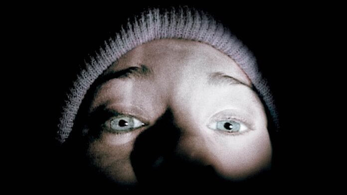 Close-up image of a terrified person illuminated by a flashlight in The Blair Witch Project